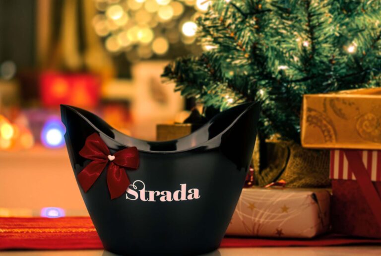 Der schöne Strada Weinkühler mit einer roten Schleife und weihnachtlichem Hintergrund.